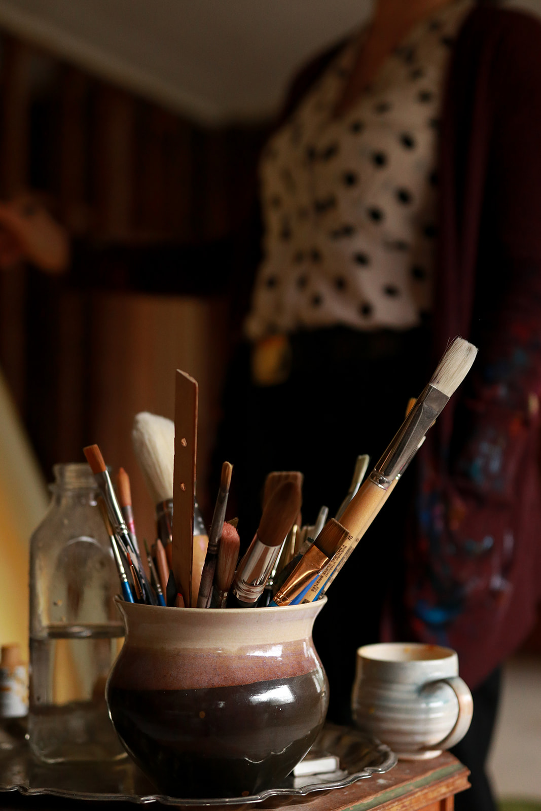 Paint brushes in a ceramic pot in the lodge studio